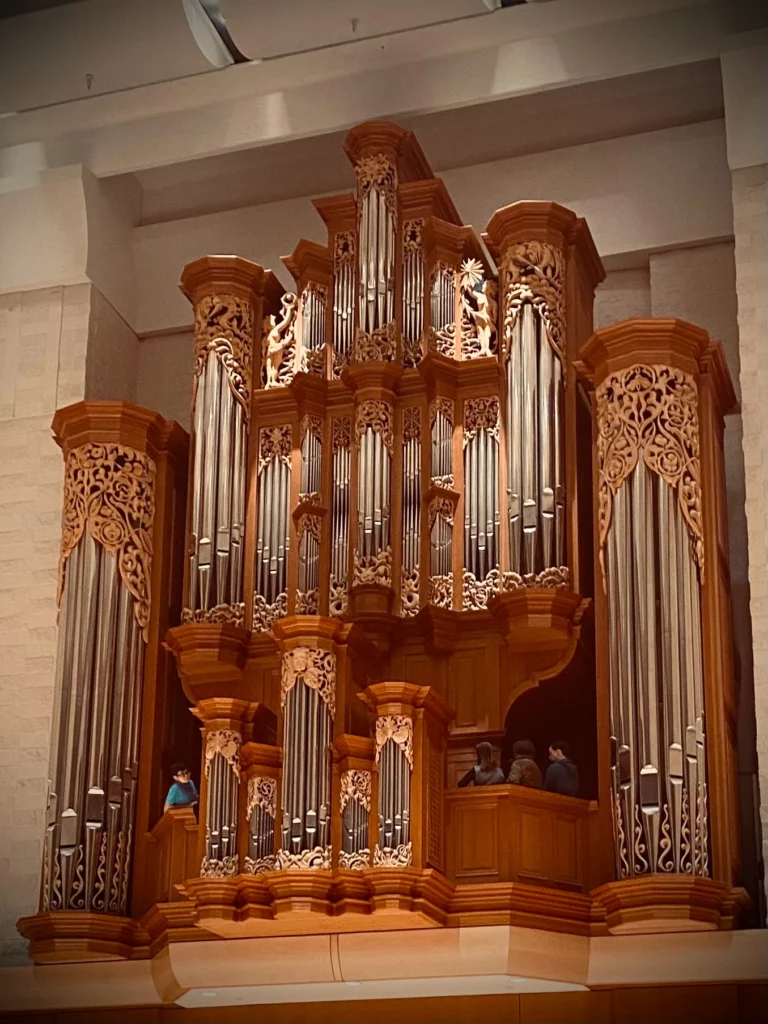 Four people standing in organ gallery