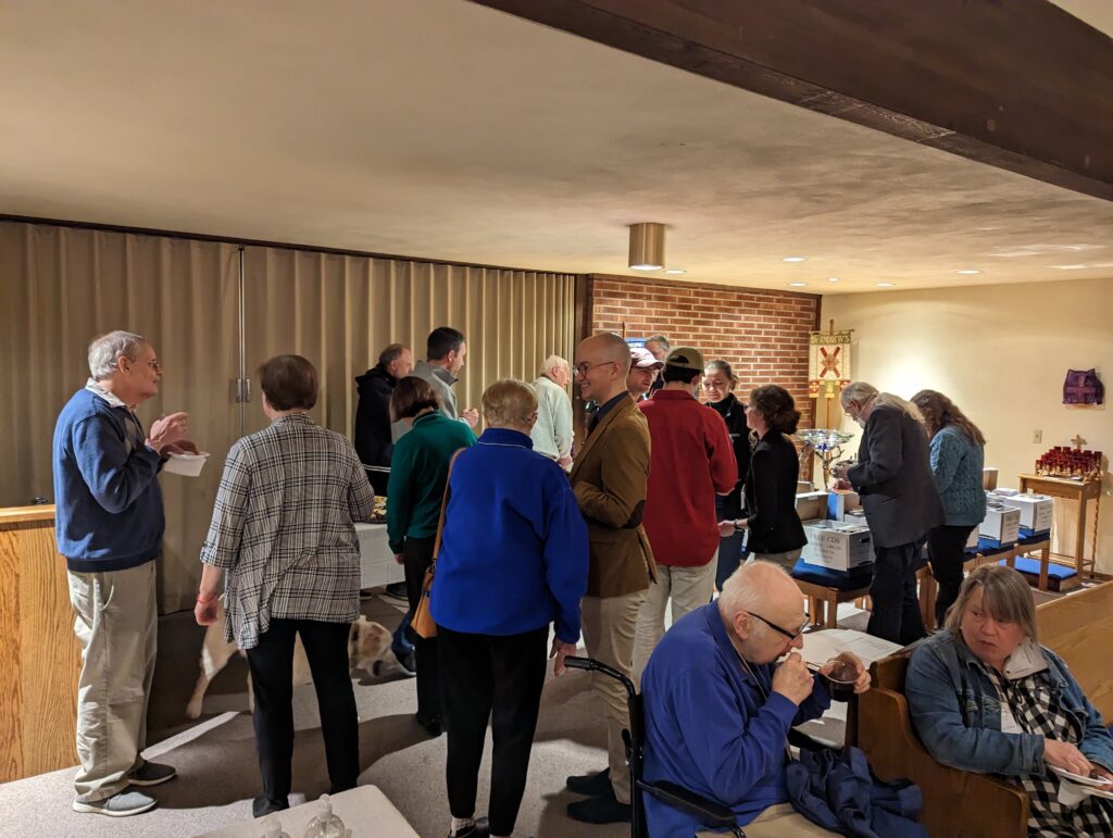 Group of people talking and eating refreshments