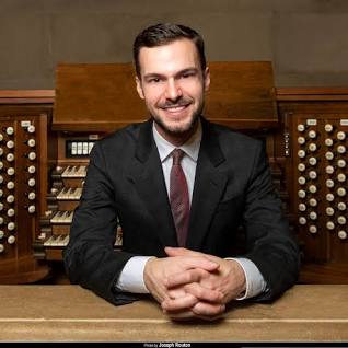 portrait of man sitting at an organ console