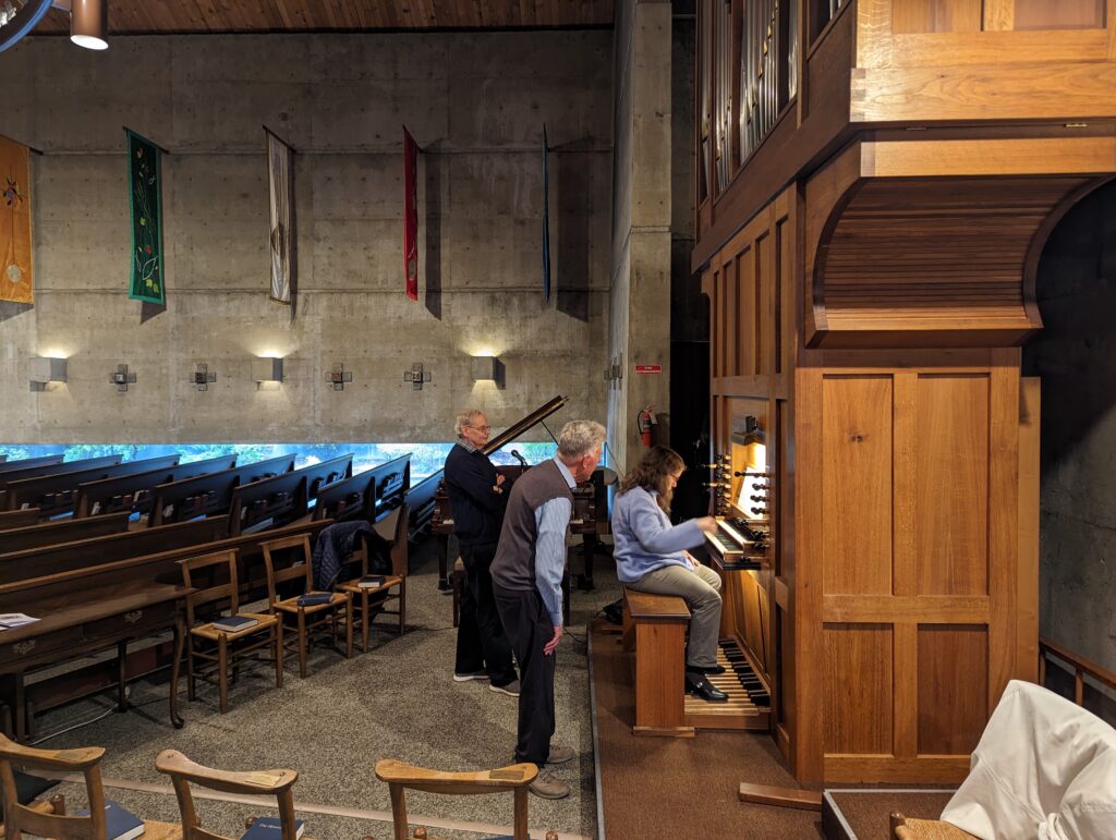 woman plays organ while two men look on