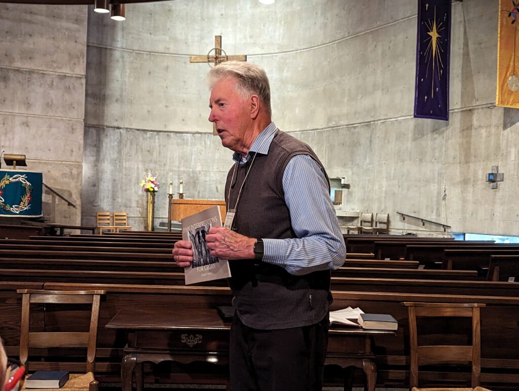 man standing and holding book of music