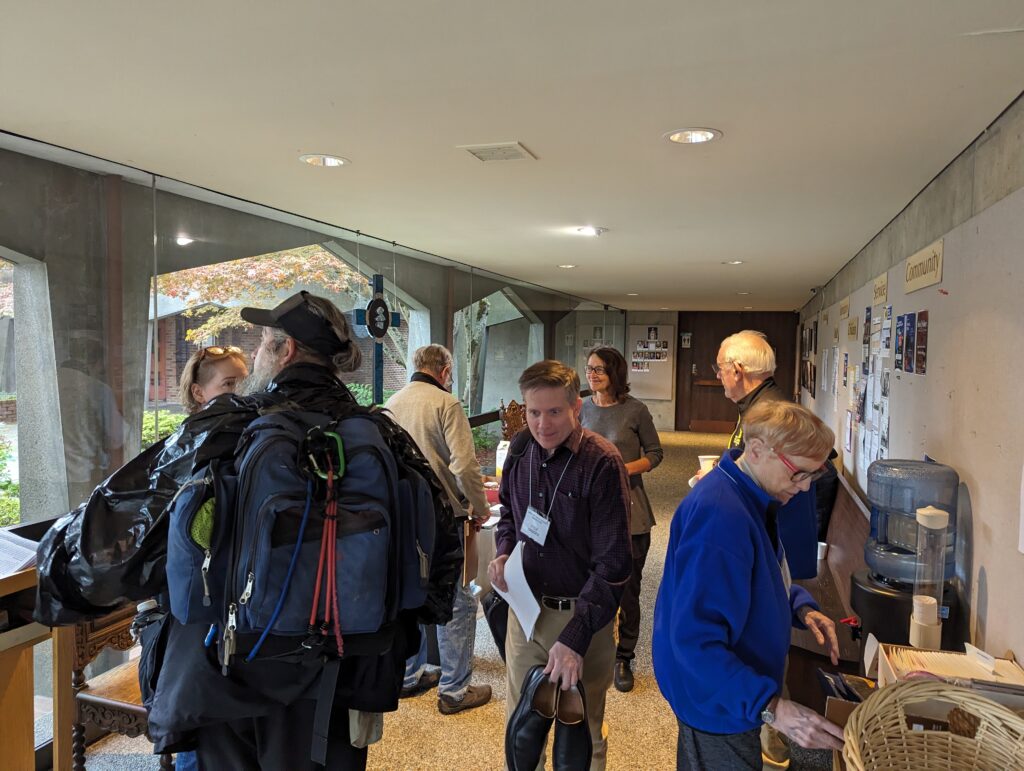 group of people in a lobby drinking coffee with man carrying shoes